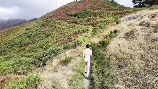A nude stud runs and ambles in nature