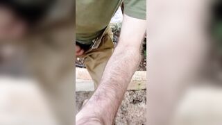 A sporty stud in a military uniform strokes off and ejaculates outdoors