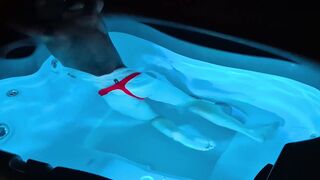 A fellow takes a bathtub at night in a lit tub and gets sexually aroused