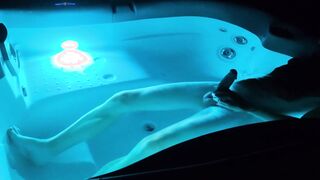 A fellow takes a bathtub at night in a lit tub and gets sexually aroused