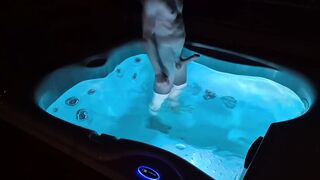 A fellow takes a bathtub at night in a lit tub and gets sexually aroused