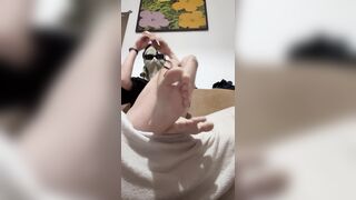 hooded youngster taking off his socks and showcasing soles