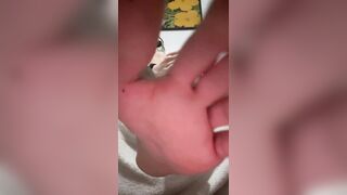 hooded youngster taking off his socks and showcasing soles