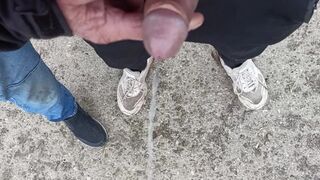 Buddy is holding my pecker while im pissing on the ground outdoor