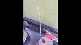 Pissing off the side of a jet ski into the water urinating outdoors