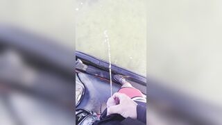 Pissing off the side of a jet ski into the water urinating outdoors