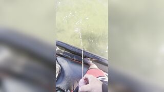 Pissing off the side of a jet ski into the water urinating outdoors