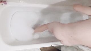 A fellow takes a tub in a tub, turning in different postures