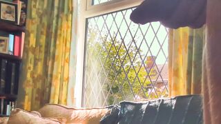 Having joy nude next to a window in utter glance with traffic passing by