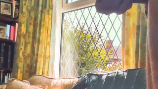 Having joy nude next to a window in utter glance with traffic passing by