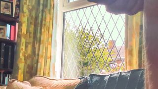 Having joy nude next to a window in utter glance with traffic passing by